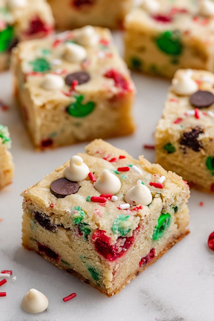 Christmas Cookie Bars, easy holiday cookie bars, festive dessert recipes, no-bake Christmas treats, colorful holiday cookie bars - The image shows square pieces of soft, light-colored cookie bars spread out on a white marbled surface. Each bar has two layers: a thick, slightly crumbly beige cookie base studded with colorful red and green candy pieces, along with dark and white chocolate chips scattered evenly throughout. The top layer is the same cookie dough with visible embedded candy and chips, giving a festive look. Small white and red sprinkles are also scattered on the surface of the bars. Photo taken with an iphone --ar 2:3 --v 7