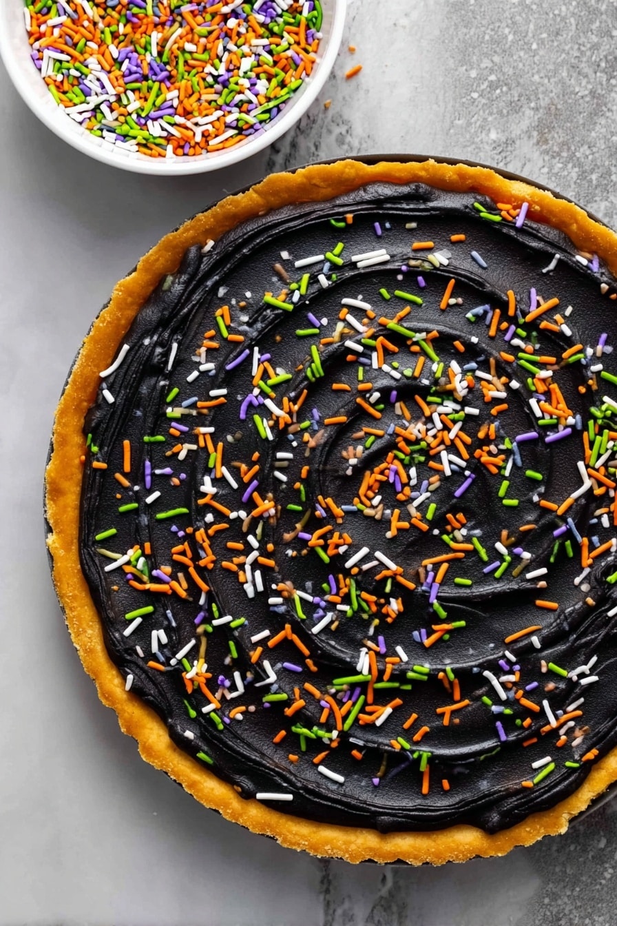 Halloween Pumpkin Spice Cookie Cake with Cream Cheese Frosting, fall pumpkin spice dessert, Halloween festive treat, easy cookie cake recipe, pumpkin spice holiday baking - A round tart with a golden-brown crust forms the base layer, topped with a thick, smooth layer of black frosting spread evenly across the surface with visible swirl textures. Colorful sprinkles in green, orange, white, and purple are scattered evenly over the black frosting, adding bright pops of color. A white bowl filled with the same sprinkles is placed above the tart on a white marbled surface, visible in the top right corner of the image. photo taken with an iphone --ar 2:3 --v 7