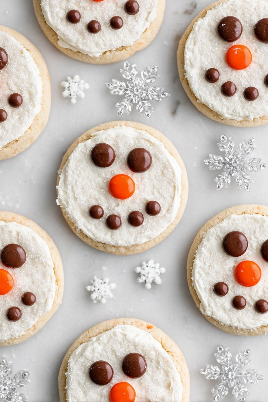 Snowman Face Cookies, Snowman Cookie Decorations, Festive Holiday Cookies, Easy Christmas Cookie Recipes, Kid-Friendly Snowman Cookies - Several round cookies are arranged on a white marbled surface, each having two layers: a light golden cookie base and a thick, even layer of white frosting with a sugar crystal texture on top. On every cookie, chocolate candies form two eyes and a smiling mouth shape, while an orange candy is placed at the center to represent a nose. Clear plastic snowflake decorations and tiny white snowflake sprinkles are scattered around the cookies, enhancing the wintry theme. photo taken with an iphone --ar 2:3 --v 7