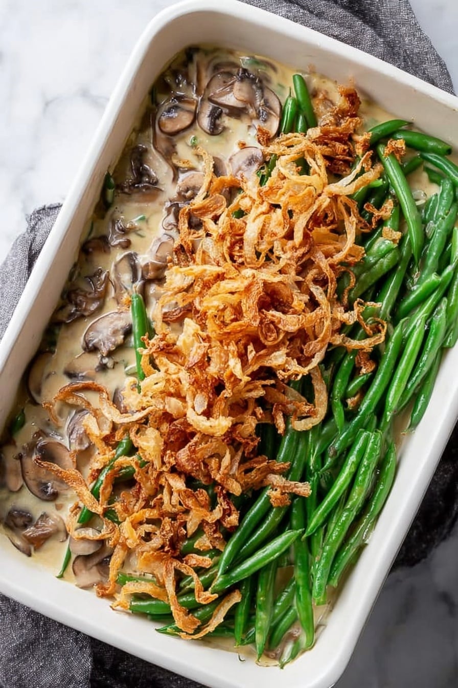 Creamy Mushroom Green Bean Casserole with Crispy Onions, green bean casserole, mushroom side dish, holiday green bean casserole, crispy onion casserole - A white square tray filled with a single thin layer of crispy fried onion strings, showing a mix of pale golden and light brown colors, some pieces are curled and others are straight, with slight dark brown edges indicating toasted spots. The texture looks crunchy and scattered unevenly across the tray, resting on a white marbled surface. Photo taken with an iphone --ar 2:3 --v 7