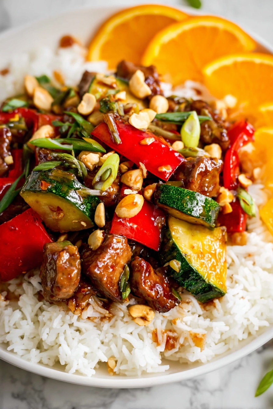 Kung Pao Chicken, Chinese stir-fry, spicy chicken dishes, homemade Kung Pao, Asian chicken recipes - The dish is served on a white plate with a base layer of fluffy white rice spread evenly. On top of the rice, there is a colorful mix of stir-fried vegetables and meat pieces. The vegetables include vibrant red bell peppers and green zucchini chunks, both cut into bite-sized pieces with a glossy, cooked texture. Scattered throughout are small chunks of browned meat coated in a shiny, slightly sticky sauce. There are also whole light brown peanuts and thinly sliced green herbs sprinkled on top, adding some texture and color contrast. In the background, there are slices of bright orange fruit, adding a fresh, citrusy touch. The whole presentation sits on a white marbled surface. photo taken with an iphone --ar 2:3 --v 7