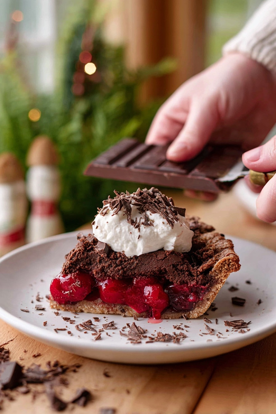 Chocolate Cherry Black Forest Pie, Black Forest Pie, Cherry Chocolate Pie, Black Forest Dessert, Chocolate Cherry Pie Recipe - A slice of dark brown chocolate pie with a rough textured top layer sits on a white plate, revealing a thick, bright red cherry filling in the middle layer. On top of the pie slice, there is a dollop of white cream with small dark chocolate shavings scattered over it and around the plate. In the background, a woman’s hand is holding a dark chocolate bar and scraping chocolate shavings. The scene is set on a wooden surface with a soft focus of green plants and warm-toned decor in the background, all on a white marbled texture. photo taken with an iphone --ar 2:3 --v 7