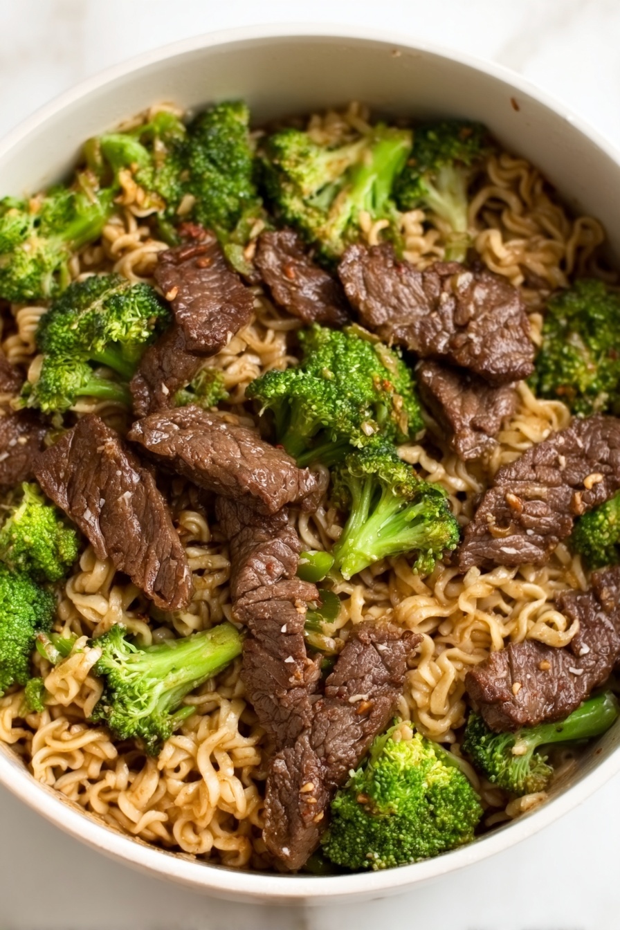 Beef and Broccoli Ramen Stir Fry, Beef and Broccoli Stir Fry, Ramen Noodle Stir Fry Recipes, Easy Beef Stir Fry, Quick Ramen Dinner - A white bowl filled with a noodle dish topped with several pieces of dark brown cooked meat arranged evenly across the surface, mixed with bright green broccoli florets scattered throughout. The noodles underneath are light brown and slightly wavy, filling the entire bowl, with the meat and broccoli sitting on top. The glossy texture of the meat contrasts with the softer noodles and the fresh look of the broccoli, all placed on a white marbled surface. Photo taken with an iphone --ar 2:3 --v 7