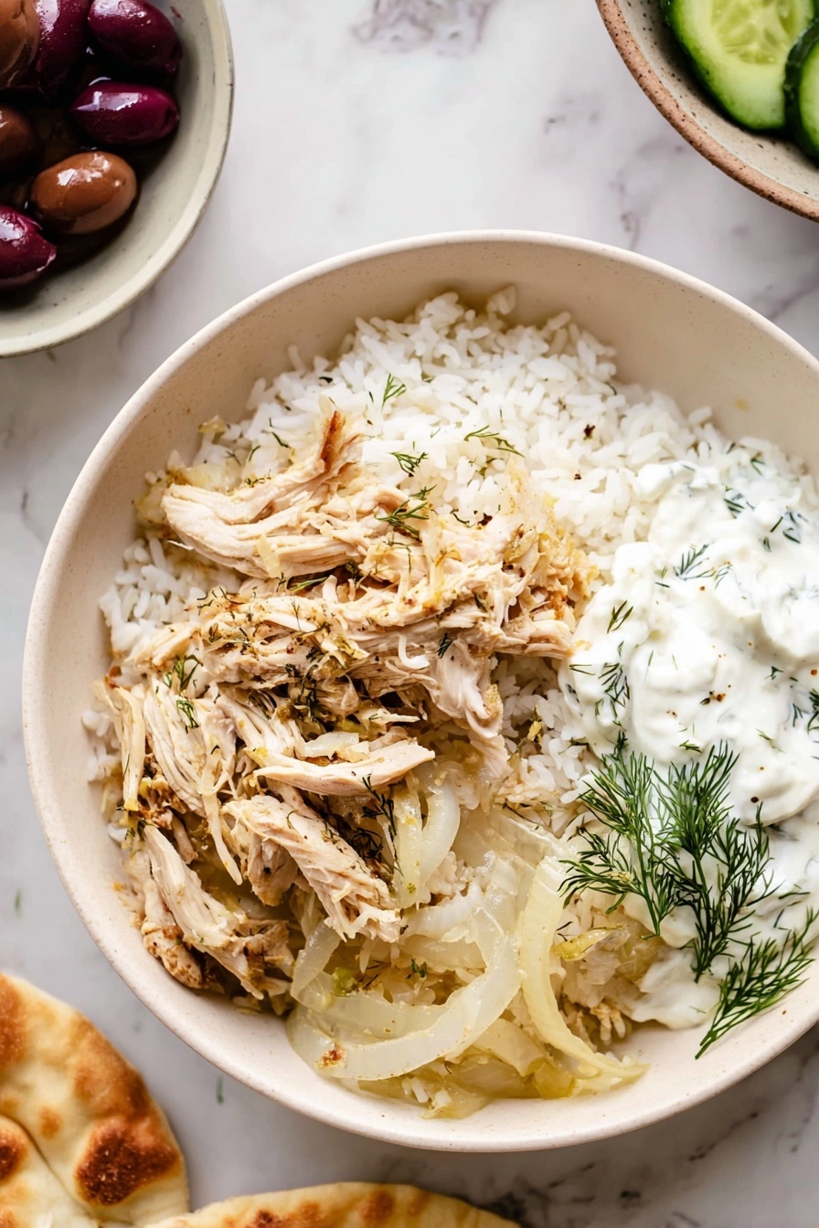 Slow Cooker Greek Chicken, Greek chicken recipe, easy Greek chicken, Mediterranean chicken dinner, healthy slow cooker chicken - A white bowl on a white marbled surface filled with three main layers: the bottom layer is white rice with a fluffy texture, the middle layer consists of cooked translucent onion slices with light browning, and on top are shredded light beige chicken pieces seasoned with herbs. On one side of the bowl, a dollop of white creamy sauce with green dill leaves is placed. Around the bowl, on the white marbled surface, there is a partial view of a white bowl holding dark purple olives and green cucumber slices, and a woman's hand is holding a piece of light golden flatbread. photo taken with an iphone --ar 2:3 --v 7