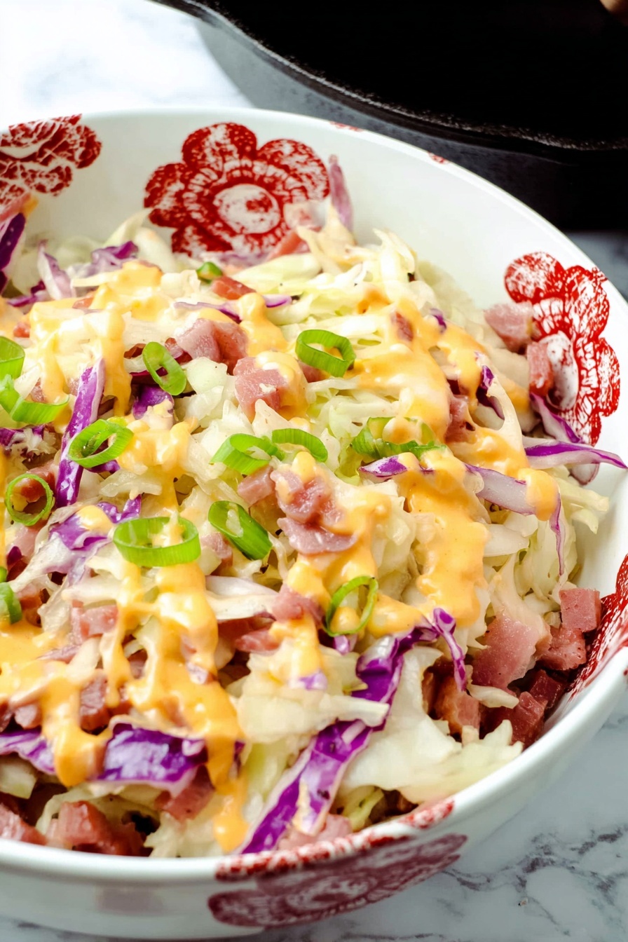 Keto Reuben Bowl with Corned Beef, Keto Reuben Bowl recipe, low-carb Reuben Bowl, easy keto lunch ideas, gluten-free Reuben bowl - The dish is shown in a black cast iron skillet filled with layers of shredded white and purple cabbage, small pieces of thinly sliced reddish meat, melted creamy white and orange cheeses drizzled on top, and sprinkled with bright green chopped onions. The cabbage forms the base with soft, thin textures, scattered evenly across the skillet. The meat pieces are scattered between the cabbage layers, adding a touch of reddish brown color. The cheese layers blend smoothly over the top with thick drips of orange sauce and melted white cheese covering the surface. Bright green onion pieces are spread on top in small round slices for a fresh look. The skillet sits on a white marbled surface with a white cloth visible in the background. photo taken with an iphone --ar 2:3 --v 7