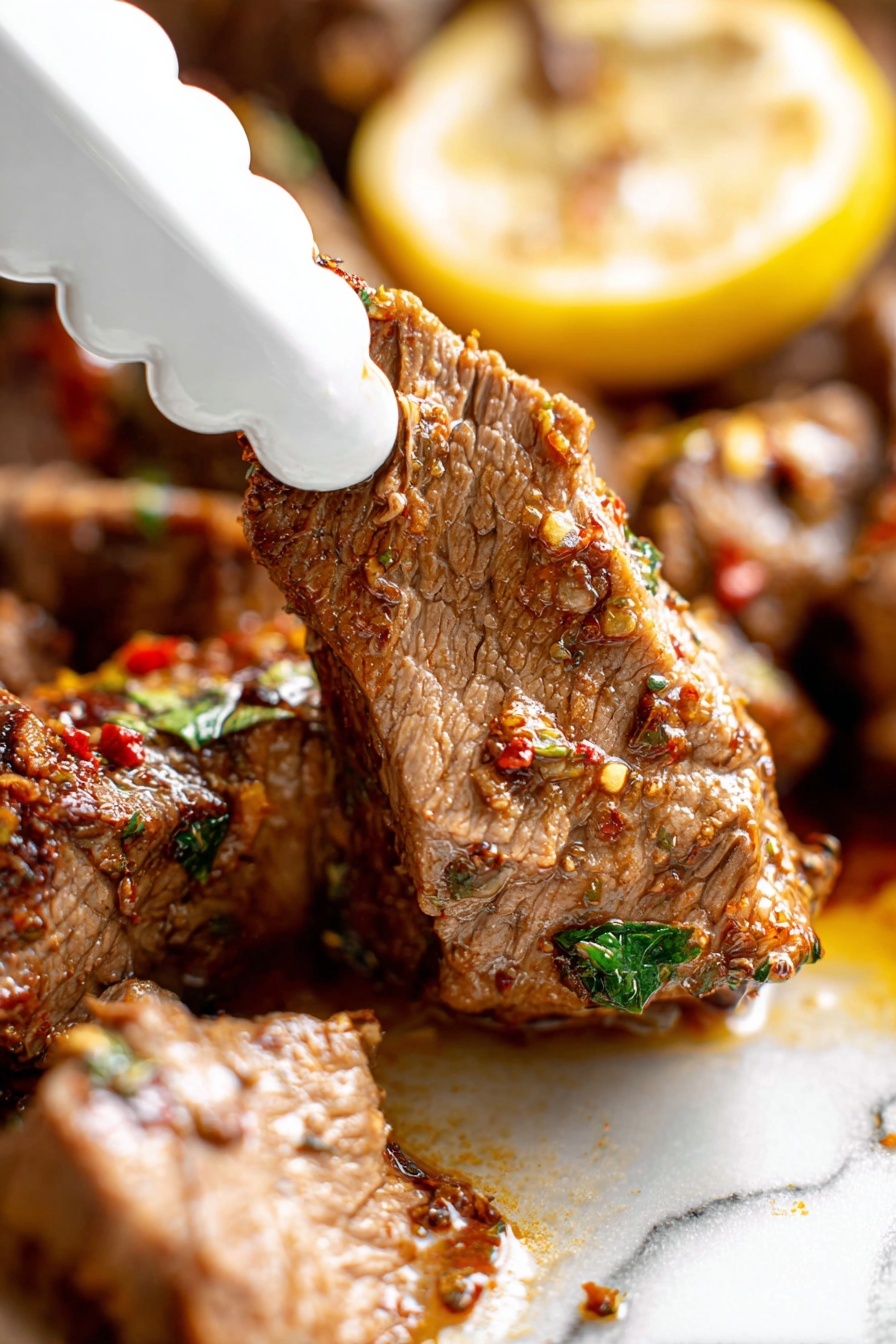 Slow Roasted Lamb Shoulder with Mint Sauce, Lamb Shoulder recipes, Roast Lamb shoulder, Mint sauce for lamb, Easy lamb roast recipe - A close-up view of a piece of cooked meat being picked up by a white scalloped-edge tong, showing its tender texture with visible fibers and seasoning bits in red and green. The meat is brown with a moist surface, sitting next to a larger piece with the same texture, all on a white marbled surface. Behind the meat, there is a yellow lemon slice with some herbs on top, adding a pop of color. The scene is bright and focused on the meat’s juicy and spiced detail, photo taken with an iphone --ar 2:3 --v 7