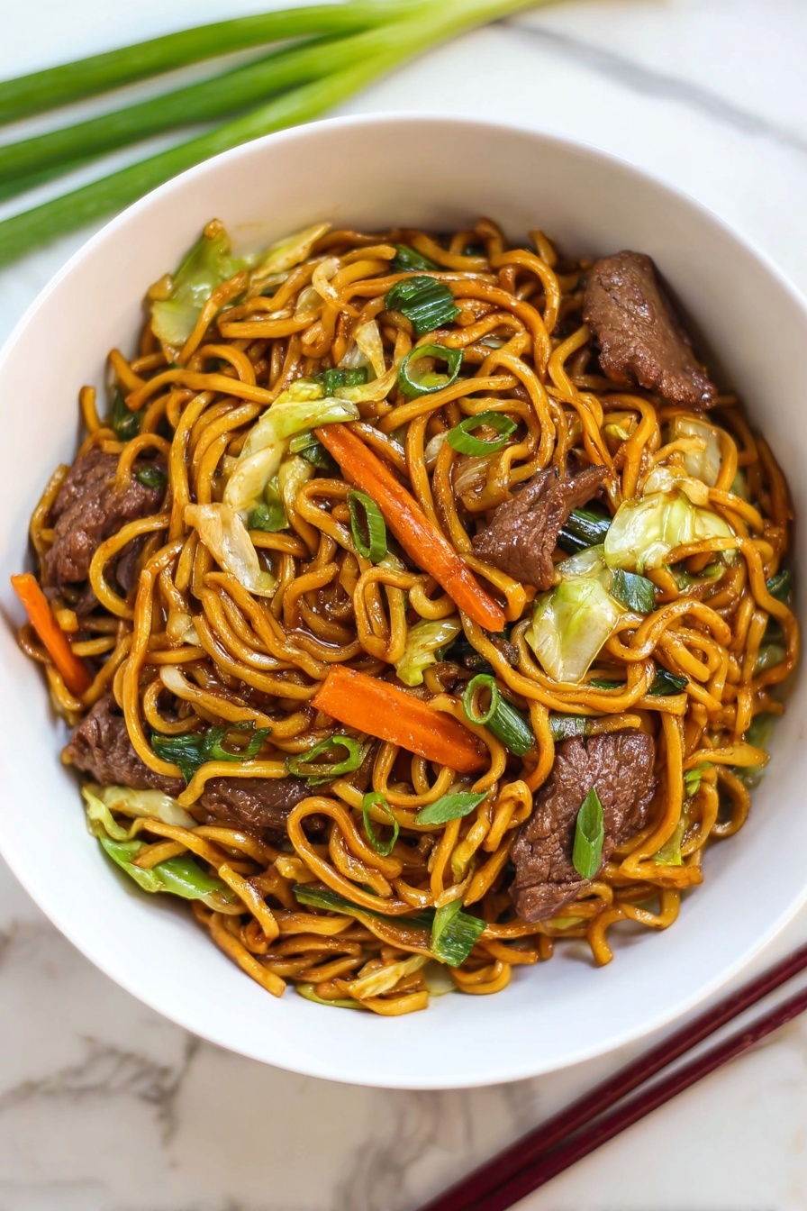 Beef Lo Mein Stir Fry, easy beef lo mein, quick Asian stir fry, flavorful beef noodles, homemade lo mein recipe - A white bowl filled with stir-fried noodles piled in the center with a shiny, dark orange color. Mixed throughout the noodles are pieces of cooked dark brown meat, bright orange carrot strips, light green cabbage leaves, and green onions with a fresh texture. The bowl sits on a white marbled surface, with green onions and dark red chopsticks placed nearby. The dish looks warm and saucy with a mix of soft vegetables and tender meat photo taken with an iphone --ar 2:3 --v 7