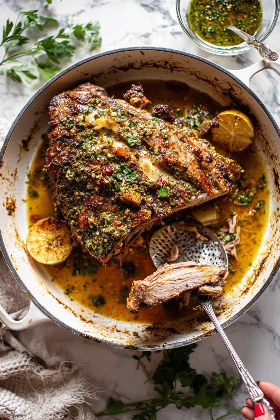 Slow Roasted Lamb Shoulder with Mint Sauce, Lamb Shoulder recipes, Roast Lamb shoulder, Mint sauce for lamb, Easy lamb roast recipe - A large piece of roasted meat with a brown crispy herb crust on top sits in the center of a white cast iron pot. The meat has visible bone, and the herb crust includes green parsley and spices giving a textured, uneven surface. Underneath the meat, there is a golden-brown juicy sauce with visible slices of lemon and pieces of cooked onions. A metal fork held by a woman's hand is pulling apart a slice of the tender meat, revealing its soft inner texture. To the right inside the pot is a hammered metal spoon resting in the sauce. Around the pot, there are scattered fresh green herbs on a white marbled surface, and a small glass bowl with herb sauce is placed behind the pot. photo taken with an iphone --ar 2:3 --v 7