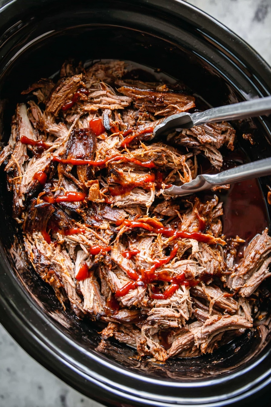 Slow Cooker Pulled Pork, Tender Pulled Pork Recipes, Easy Pulled Pork Dinner, Juicy Slow Cooker Pork, Best Pulled Pork Method - A close-up image of shredded cooked meat with dark brown edges and lighter brown inside, placed inside a black slow cooker. The meat is covered with red sauce drizzled unevenly over the top. A silver fork and silver tongs are partially visible inside the slow cooker, placed on the left and right sides of the meat. The slow cooker sits on a white marbled surface. photo taken with an iphone --ar 2:3 --v 7