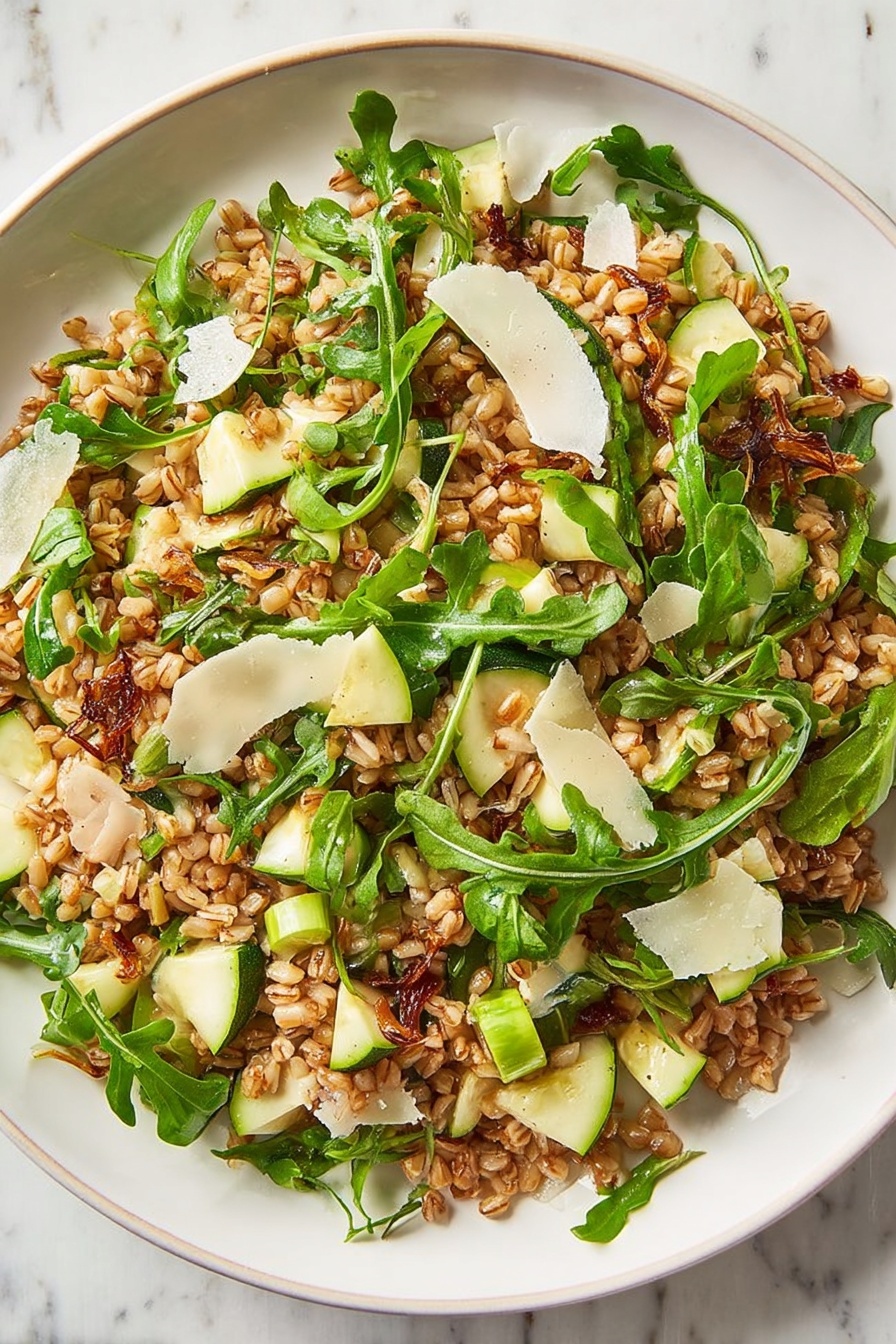 Ultimate Farro Salad with Apple and Arugula, healthy farro salad, apple arugula salad recipe, hearty grain salad with fruit, quick nutritious salad - A clear glass bowl holds a mixed salad with three main layers: a bottom layer of cooked brown grains, a middle layer of bright green arugula leaves with thin stems, and a top layer scattered with thin white cheese shavings and small green apple pieces. The grains look slightly shiny, and the arugula adds a fresh, leafy texture. The bowl sits on a white marbled surface with two empty white bowls in the background. Photo taken with an iphone --ar 2:3 --v 7