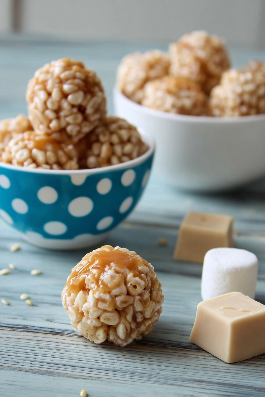 Caramel Marshmallow Rice Krispies Puffs, Rice Krispies treats with caramel and marshmallows, easy caramel Rice Krispies snacks, homemade caramel marshmallow puffs, dessert ideas with Rice Krispies - The image shows small round treats with a light caramel center covered in a layer of puffed rice. There are three of these treats inside a white bowl with blue and white polka dots on the left side of the image, and a white bowl filled with more treats is in the background on a white marbled surface. Two caramel squares and a large white marshmallow are placed behind one treat in the middle foreground, and a single treat sits on the white marbled surface near the front. The treat's outer puffed rice layer is beige and textured, while the caramel inside is shiny and smooth. photo taken with an iphone --ar 2:3 --v 7