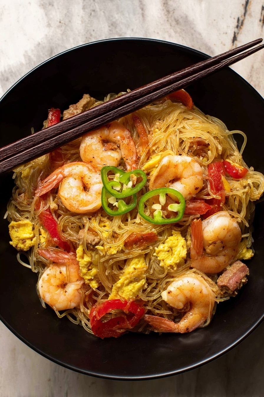 Singapore Noodles with Shrimp and Curry, quick Asian stir-fry, shrimp curry noodle recipe, easy Singapore noodle dish, flavorful rice vermicelli stir-fry - The image shows a black bowl filled with a noodle dish. The bottom layer is thin, light brown noodles loosely piled. On top, there are several whole cooked shrimp with a slightly pink and orange color. Mixed in are bright red strips of bell pepper and pieces of yellow scrambled egg. There are small chunks of brown meat scattered through the dish. Thin slices of green chili peppers are placed on the top, adding a fresh color contrast. A pair of dark brown chopsticks rest across the bowl on the top edge. The bowl is set on a surface with a white marbled texture. photo taken with an iphone --ar 2:3 --v 7