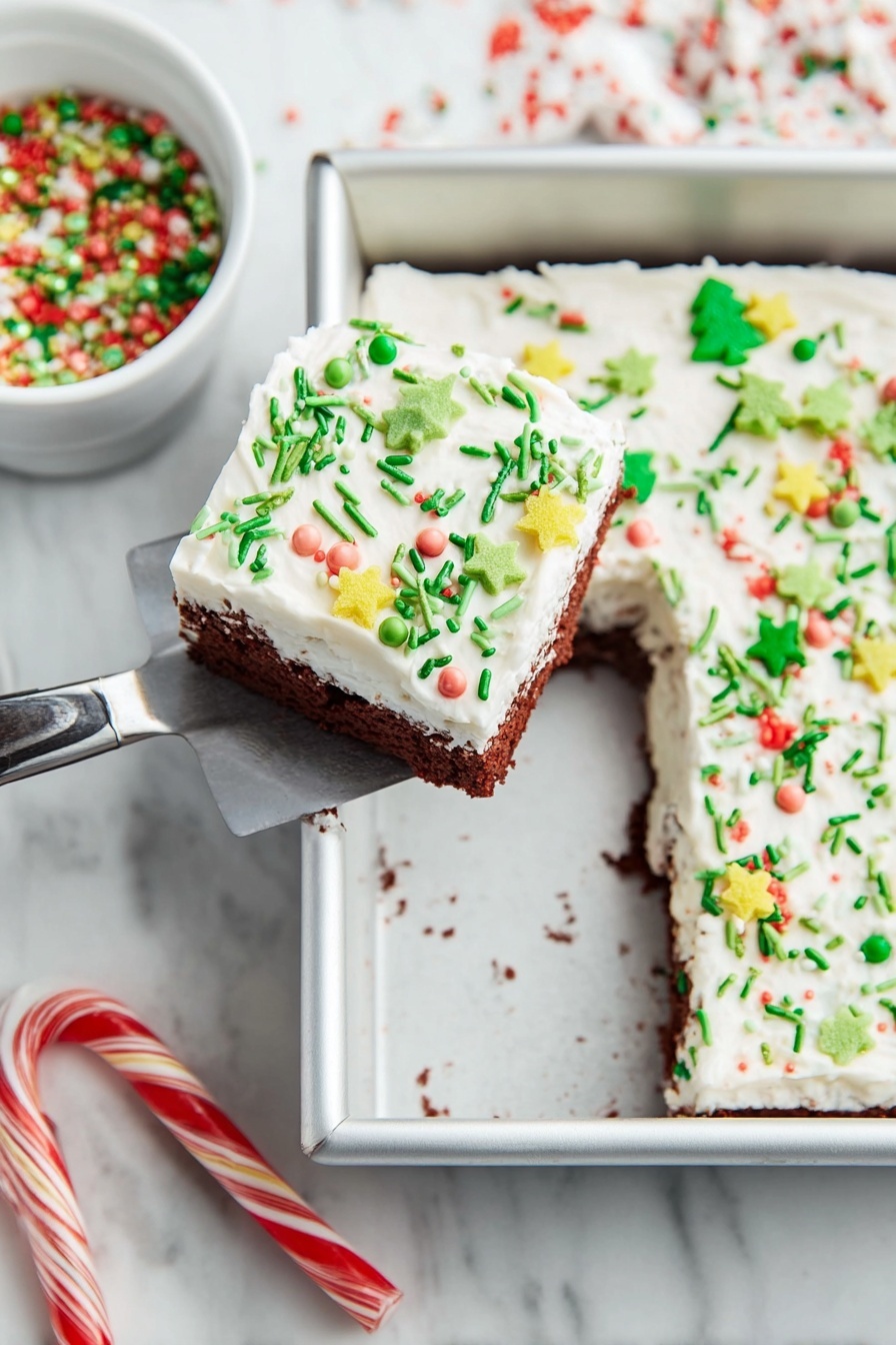 Christmas Red Velvet Lasagna Dessert, festive red velvet dessert, holiday layered dessert, Christmas holiday dessert ideas, easy Christmas dessert recipes - A square piece of cake with two layers is lifted by a spatula above a white marbled surface. The cake’s bottom layer is chocolate brown, and the top is a thick white frosting spread evenly. The frosting is decorated with various colorful sprinkles, including green thin rods, small round pearls in pastel colors, yellow star shapes, and green Christmas tree shapes with red round sprinkles. The cake is in a silver baking pan with one piece missing from it. Nearby, there is a white bowl filled with green, red, and white holiday sprinkles. Two candy canes lie on the white marbled surface below the pan. Photo taken with an iphone --ar 2:3 --v 7