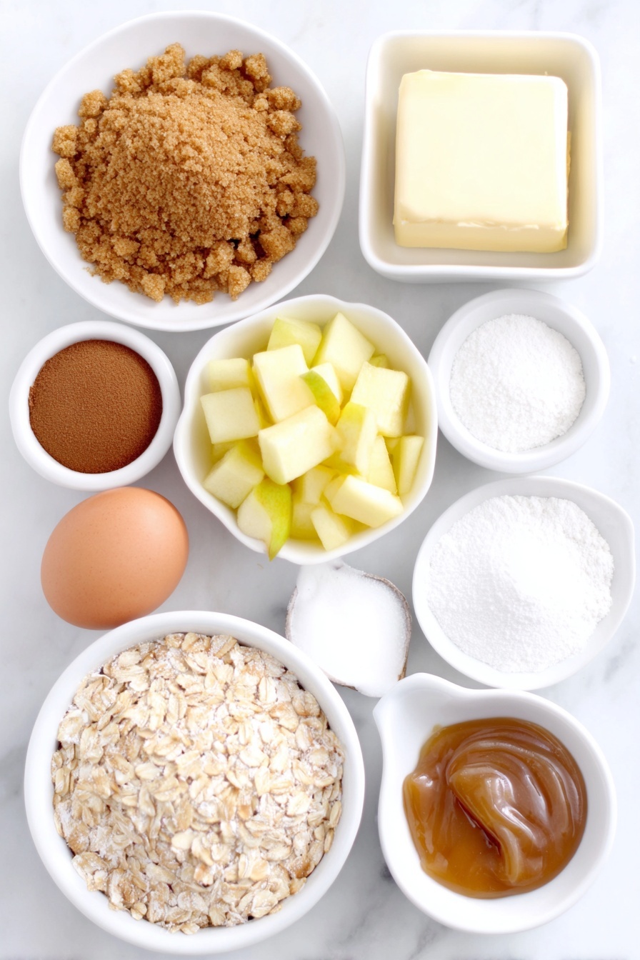 Apple Cinnamon Cheesecake Cupcakes, apple cinnamon cupcakes, cheesecake cupcakes with apples, spiced apple dessert, easy apple cheesecake treats - Flat lay of a small pile of golden graham cracker crumbs, a neat mound of light brown sugar, a sprinkle of ground cinnamon in a small white bowl, a few curls of melted unsalted butter in a white ceramic dish, a small bowl of all-purpose flour, a heap of quick-cooking oats, a white ceramic bowl with a dusting of ground nutmeg, two medium-small peeled apples chopped finely, a small white ceramic bowl with freshly squeezed lemon juice, a block of soft cream cheese on a plain white plate, a clean whole brown egg, a small white bowl with granulated sugar, a small white bowl of vanilla extract, a small white bowl of cornstarch, and a white ceramic dish with golden caramel sauce placed on a clean white marble surface, soft natural light, photo taken with an iPhone, professional food photography style, fresh ingredients, white ceramic bowls, no bottles, no duplicates, no utensils, no packaging --ar 2:3 --v 7 --p m7354615311229779997