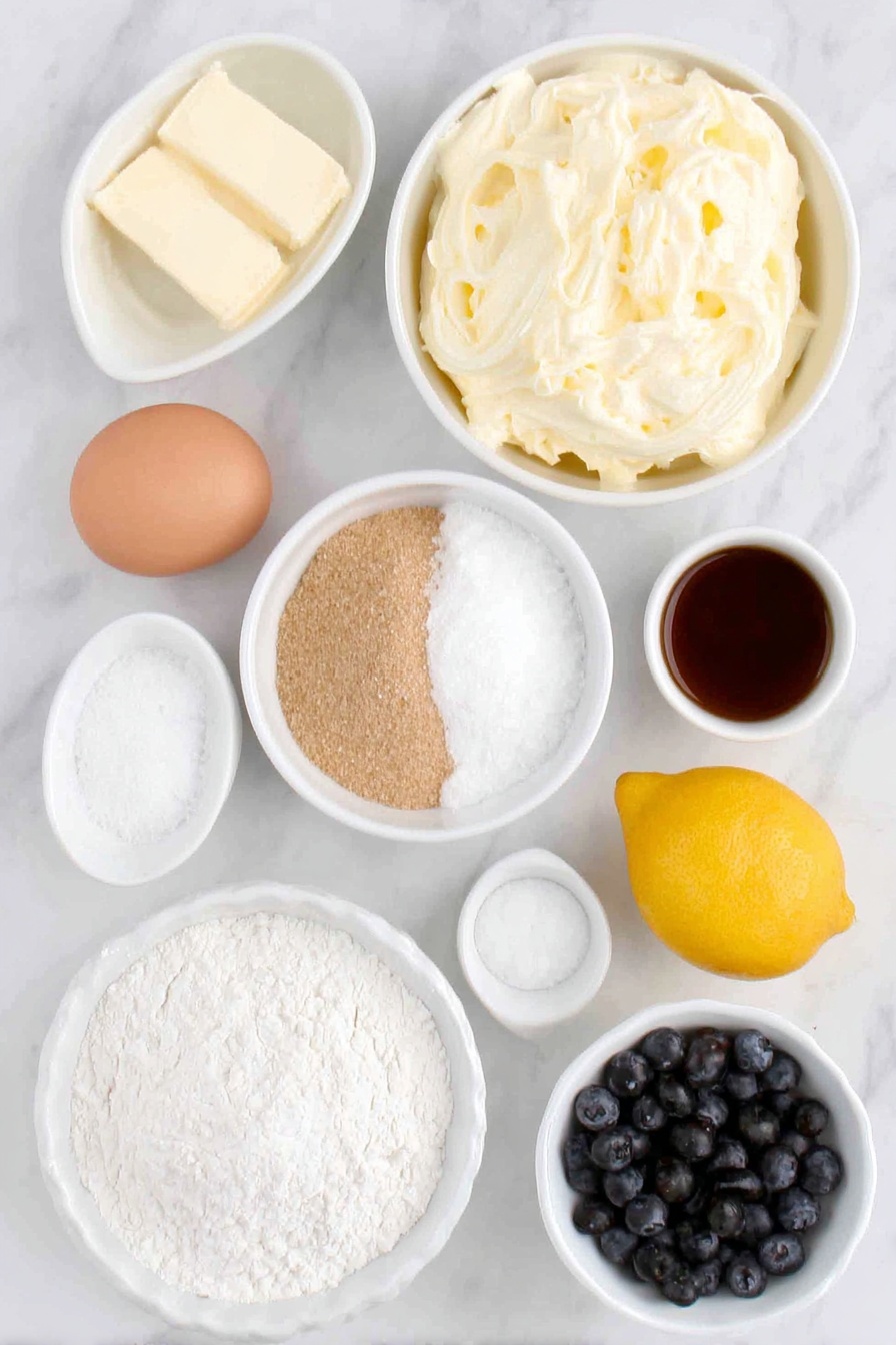 Lemon Blueberry Cookies, lemon blueberry cookie recipe, lemon blueberry baking, blueberry lemon cookies, citrus berry cookies - Flat lay of a small white ceramic bowl of softened unsalted butter, a small white ceramic bowl of white granulated sugar, a small white ceramic bowl of light brown sugar, fresh whole lemon with bright yellow zest, one whole large egg with a clean shell, a small white ceramic bowl of fresh lemon juice, a small white ceramic bowl of vanilla extract, a small white ceramic bowl of sifted all-purpose flour, a small white ceramic bowl containing baking powder, another small white ceramic bowl with baking soda, a small white ceramic bowl of salt, a small white ceramic bowl filled with fresh wild blueberries, and a simple small white ceramic bowl of lemon zest mixed with white granulated sugar, placed on a clean white marble surface, soft natural light, photo taken with an iPhone, professional food photography style, fresh ingredients, white ceramic bowls, no bottles, no duplicates, no utensils, no packaging --ar 2:3 --v 7 --p m7354615311229779997