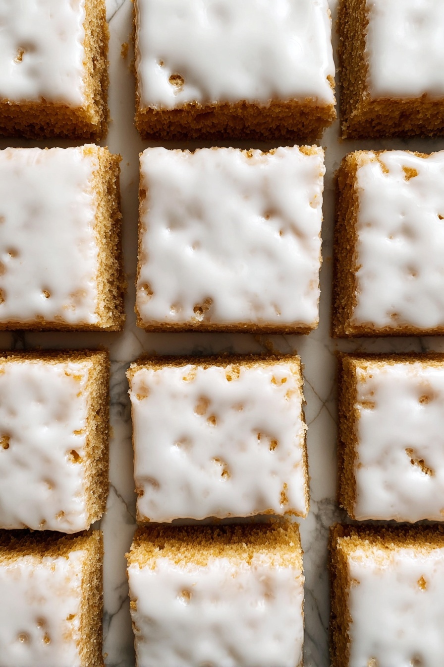 Iced Oatmeal Cookie Bars, oatmeal cookie bars with icing, chewy oatmeal dessert bars, vanilla glazed oatmeal bars, easy oatmeal cookie bar recipe - The image shows nine square pieces of a light brown cake arranged in a 3x3 grid on a white marbled surface. Each piece is thick and topped with a smooth, glossy white icing that covers the entire top layer but is slightly uneven, with some small holes and cracks revealing the cake underneath. The edges between the squares are cleanly cut, showing the dense texture of the cake layers below the shiny icing. photo taken with an iphone --ar 2:3 --v 7